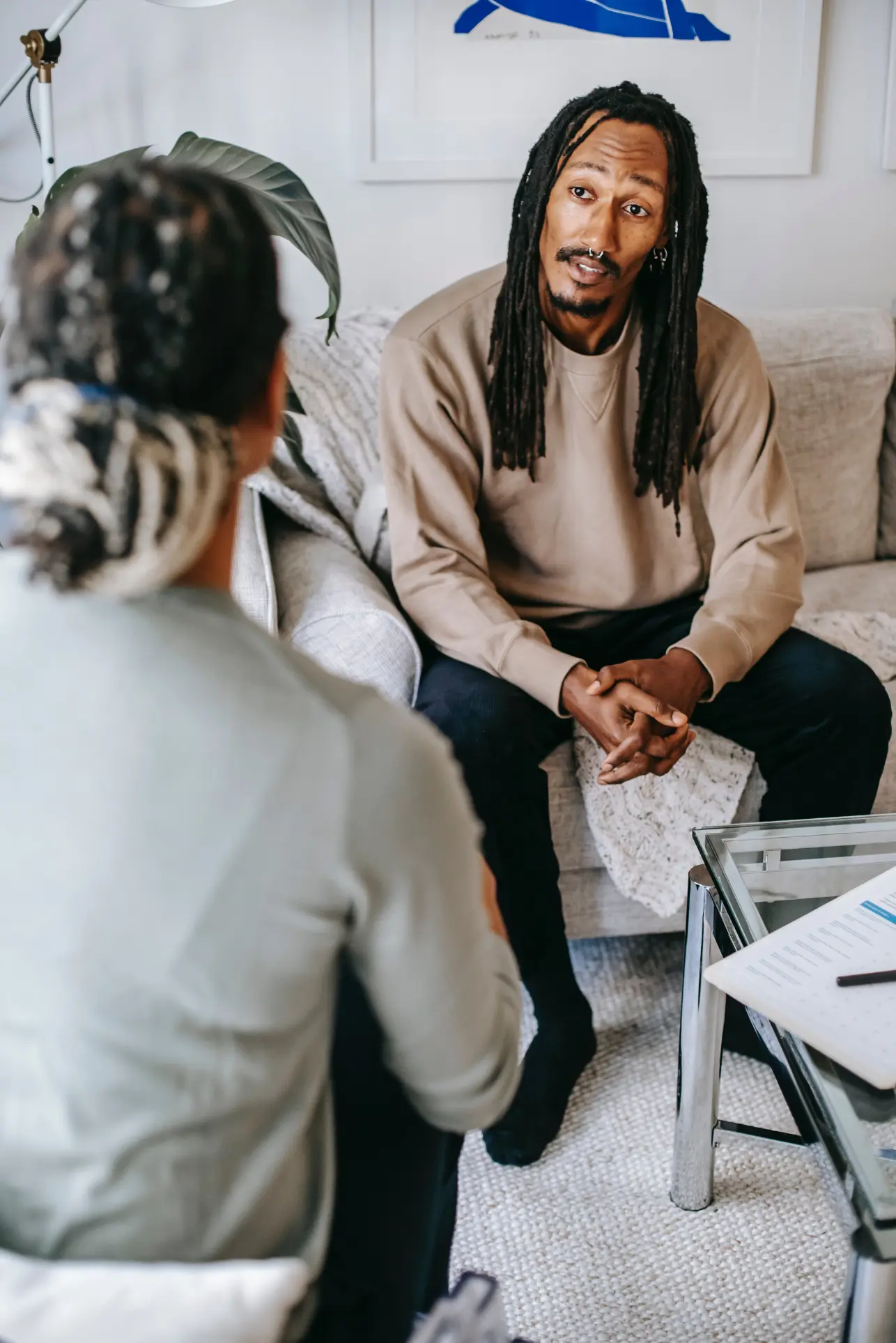 Two people conversing in cozy home setting.